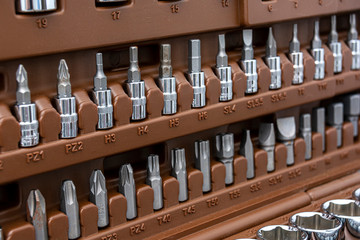 Set of metal heads for screwdriver in a box. Abstract tech background.