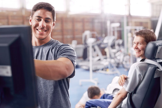 Physical Therapist At Computer Talking To Man