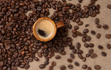 cup of coffee and beans on burlap with copy space for text.