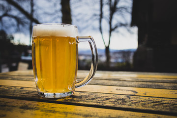 Mug of beer in a mountain hut like ambient. Jug of beer with nobody walking past in the background....