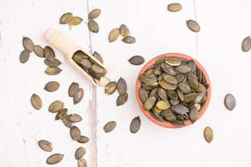 Pumkin seeds on a white shabby background, empty copy space