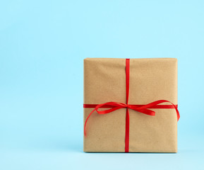 square box is packed in brown kraft paper and tied with a red thin silk ribbon