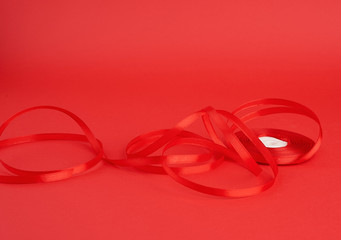 twisted red silk shiny ribbon on a red background