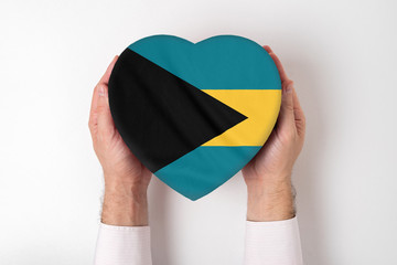 Flag of Bahamas on a heart shaped box in a male hands. White background
