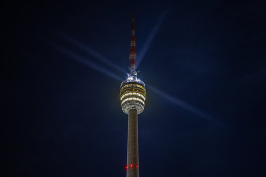 Stuttgart Television Tower (Fernsehturm) against night sky with stars and light beams, Germany