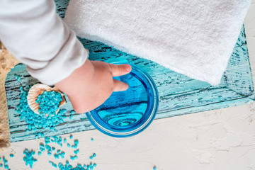 Beautiful blue spa composition. blue sea salt, liquid soap, starfish, shells and a white bath towel