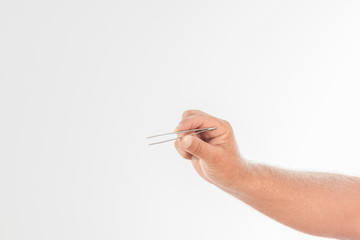 Close-up of a male hand holding tweezers