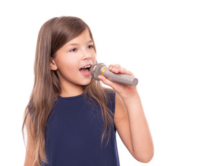 Little girl posing with a microphone for singing on a white background.
