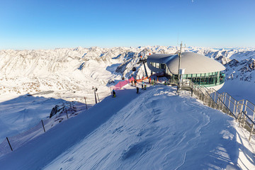 View from Pitztal glacier into the high alpine mountain landscape with cable car station and ski...