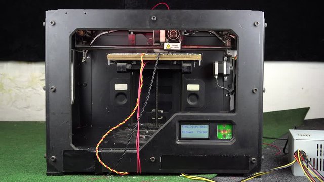 3D printer head in operation. 3D diy printer printing plastic mechanical parts .An open source diy 3d printer is printing gears and pulleys, using disposable biodegreadable PLA material (filament). 4k