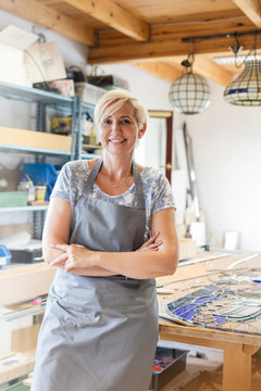 Portrait smiling stained glass artist in studio