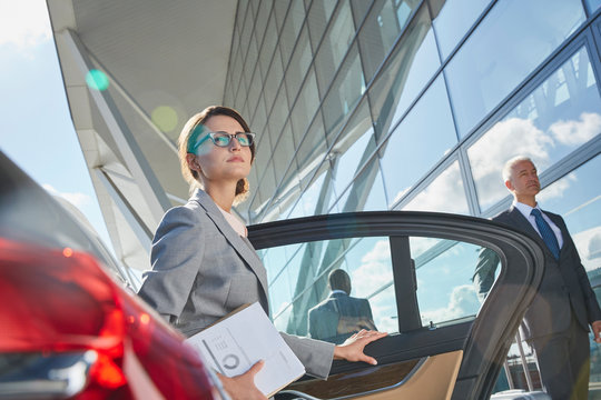 Businesswoman arriving at airport getting out of town car