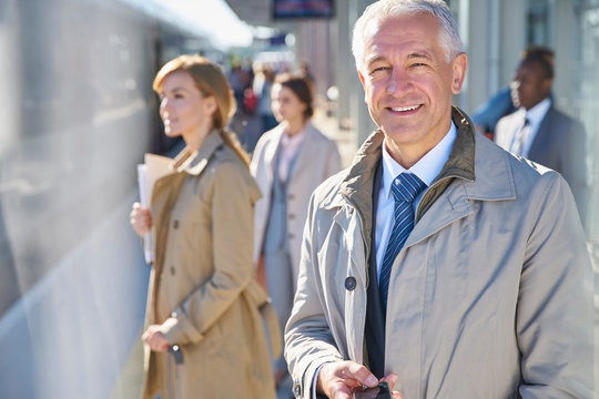 Portrait smiling businessman on sunny train station platform