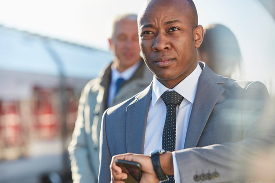 Businessman checking the time on wristwatch at train station