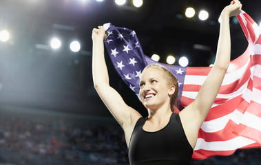 Smiling female runner running victory lap with American flag