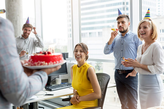 Business people celebrating birthday with cake in office