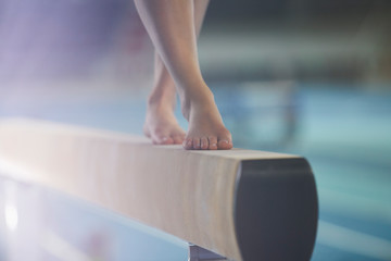 Bare feet of female gymnast performing on balance beam