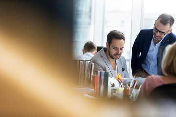 Business people reviewing paperwork at office desk