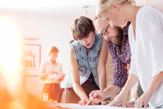 Design professionals reviewing proofs in office
