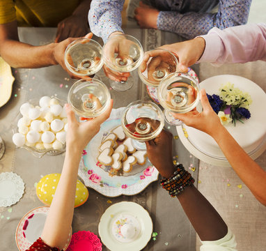 Overhead View Friends Toasting Champagne Glasses Over Easter Desserts