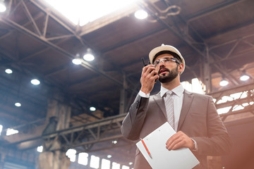 Manager with walkie-talkie in steel factory