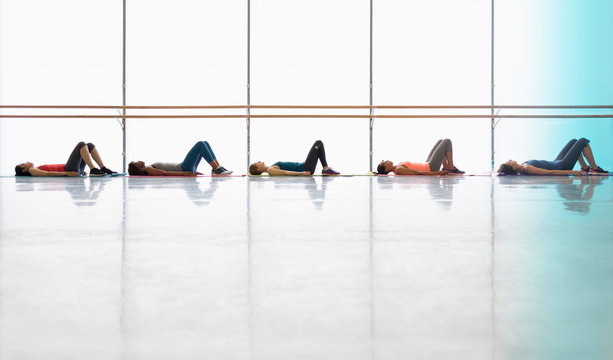 Women resting laying on yoga mats in exercise class gym studio