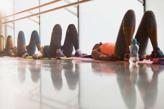 Women resting on backs in exercise class gym studio