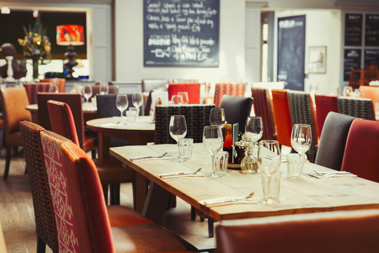 Wine glasses and silverware on table in empty restaurant
