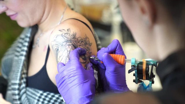 Tattoo artist tattooing an arm