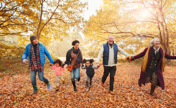 Playful multi-generation family running in autumn park