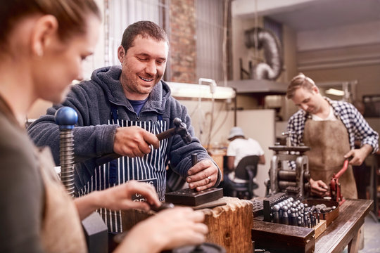 Jewelers using equipment in workshop