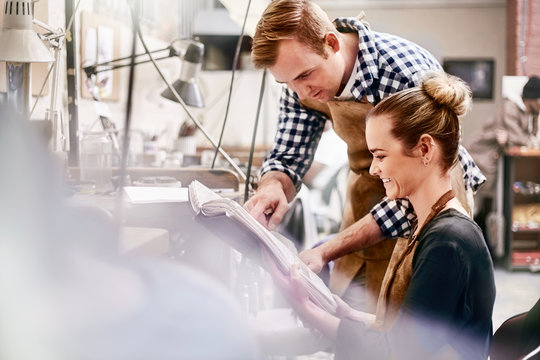 Jewelers reviewing plans in workshop