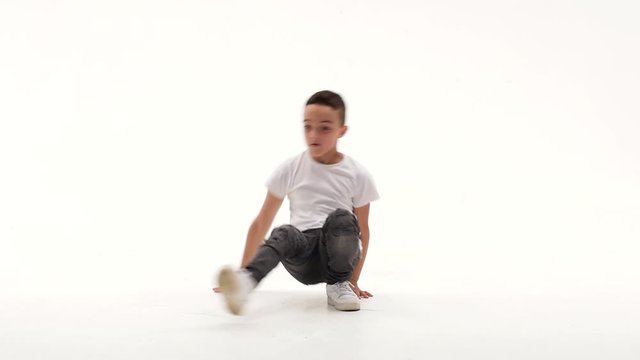 Little boy is dancing a modern dance on the white background in black leather jackets and jeans. Slow motion.