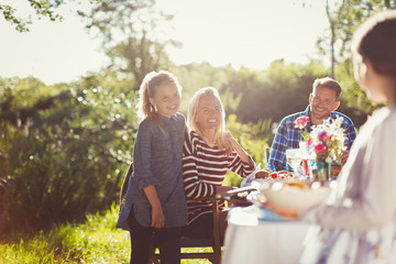 Happy family enjoying lunch at sunny garden party patio table