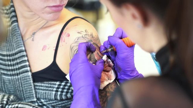 Tattoo artist tattooing an arm