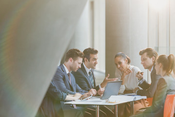 Business people using laptop in meeting