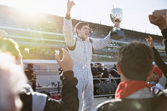 Formula One Racing Team Cheering For Driver Trophy, Celebrating Victory On Sports Track