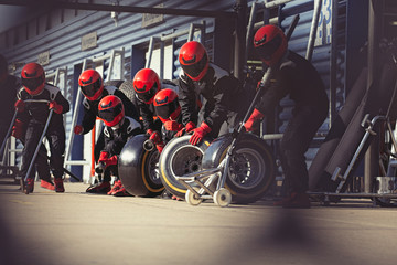 Pit crew preparing tires in formula one pit lane