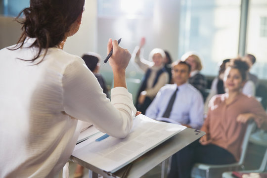 Businesswoman leading conference presentation, answering audience questions