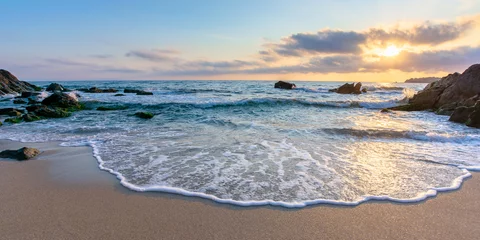 Fototapete Rund Sonnenaufgang am Strand. schöne Sommerlandschaft. Felsen im Sand. ruhige Wellen auf dem Wasser. Wolken am Himmel. weite Panoramasicht © Pellinni