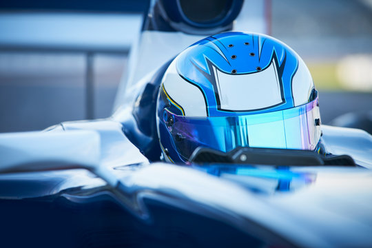 Close up formula one race car driver wearing blue helmet