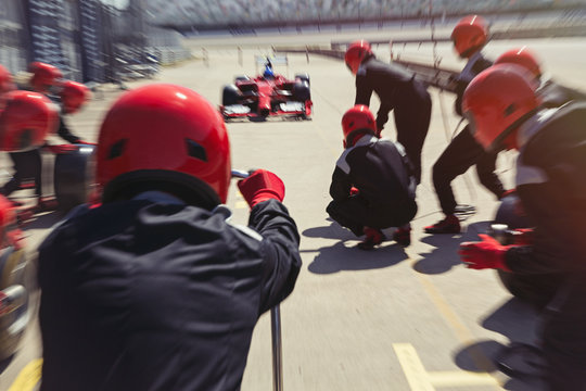 Pit crew ready for nearing formula one race car driver in pit lane