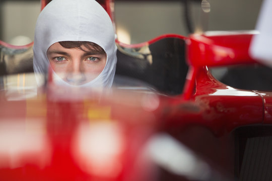 Close up portrait serious formula one race car driver wearing protective mask