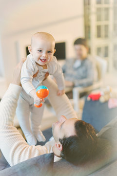 Portrait father holding cute baby son with rattle