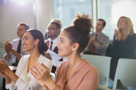 Businesswomen clapping in conference audience