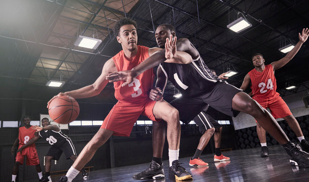 Young male basketball players playing on court in gymnasium - Powered by Adobe