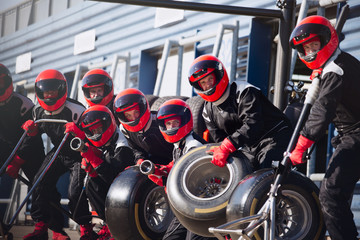 Pit crew ready with tires in formula one pit lane