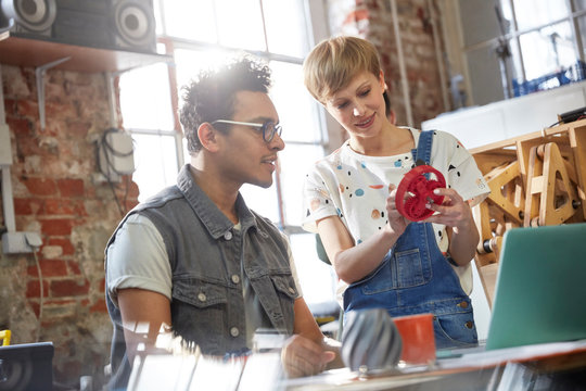 Designers discussing prototype cog in workshop