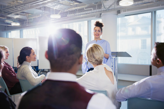 Businesswoman leading conference presentation, answering audience questions