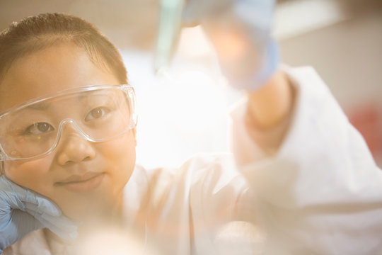 Pensive girl student conducting science experiment in classroom laboratory